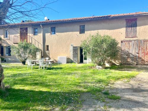a building with a table and chairs in a yard at Le Moun Mazet gîte rural 3 étoiles, CLIM, Nature, 6 personnes in Miramas