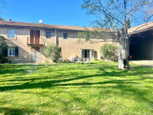 a person sitting at a table in front of a house at Le Moun Mazet gîte rural 3 étoiles, CLIM, Nature, 6 personnes in Miramas