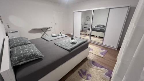 a bedroom with a bed with a cat sitting on it at Apartman Mešanović in Tuzla