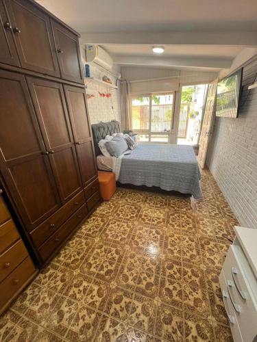 a bedroom with a bed and a tiled floor at Suíte aconchego dos pássaros in Guaratuba