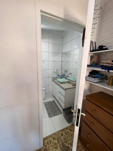 an open door to a bathroom with a sink at Suíte aconchego dos pássaros in Guaratuba