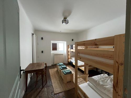 a room with a bunk bed and a desk and a table at Maison Elgenia in Saint-Martin-dʼArrossa