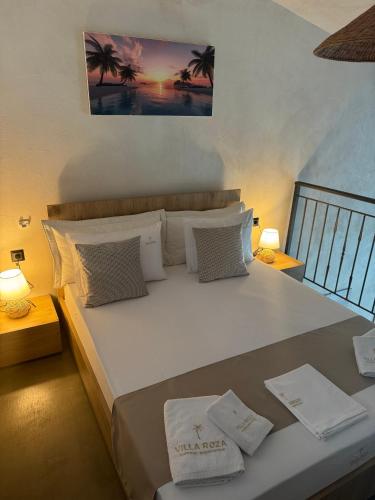 a bedroom with a large white bed with palm trees at Villa Roza 2 in Kallithea Halkidikis