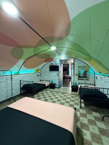 a room with a bed and tables and a ceiling at Kandinsky CASA VACANZE Relax in Monterosso Almo