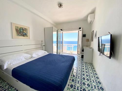 a bedroom with a blue bed and a balcony at La Dimora sul Mare in Sant'Angelo D'Ischia