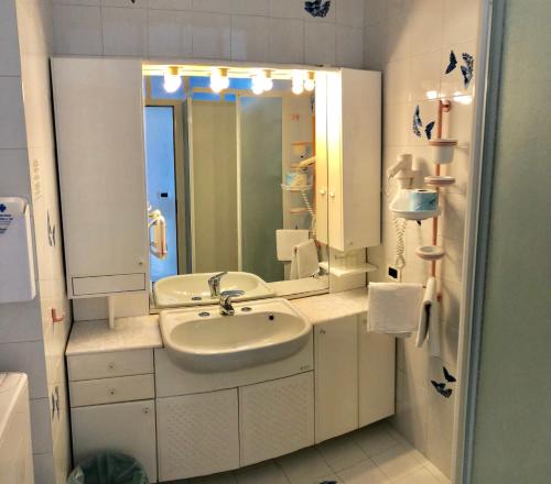 a white bathroom with a sink and a mirror at La Dimora sul Mare in Sant'Angelo D'Ischia