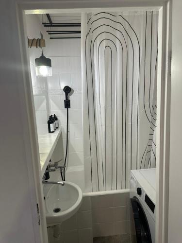 a bathroom with a shower curtain and a sink at Apartament Blue Velvet in Skierniewice