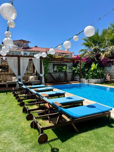 a row of chaise lounges next to a swimming pool at Windmill Alaçatı in Alaçatı