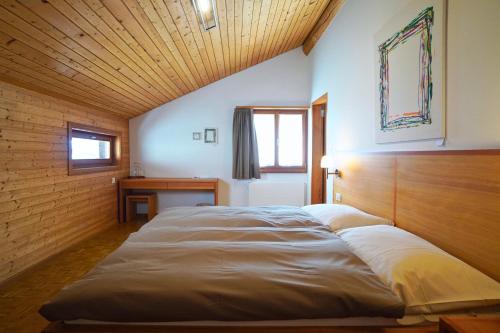 a large bed in a room with a wooden ceiling at Hotel Stüa Granda in Soglio