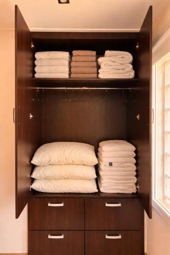 a closet filled with lots of folded towels at Cabañas Aires del Sur, con gran parque y pileta in Chascomús