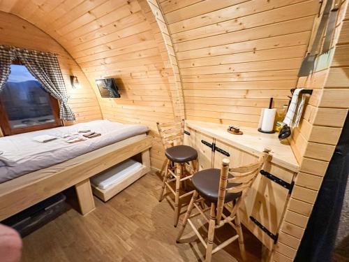 a small room with a bed and two chairs at RAZBIBRIGA - Riverside Camping Pod by IGLENA in Kupres