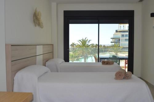 two white beds in a room with a window at Ocean Homes, Vista Mar y piscina EXCELLENT & SOLMARES in Punta del Caimán