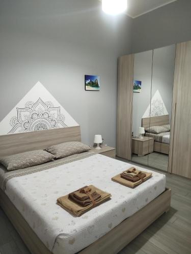 a bedroom with a large bed with two wooden mats on it at CAMARDA HOME in Bernalda