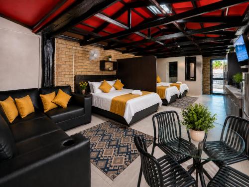 a hotel room with two beds and a couch at Royal Palms Guest House in Port Elizabeth