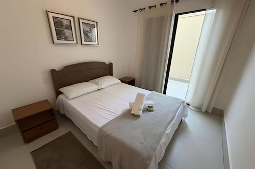 a bedroom with a bed with a book on it at Aconchegante Apartamento com Ar Condicionado in Araxá