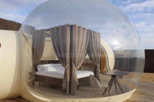 a bed in a glass orb with a table and a chair at Wine Bubble in Cuzcurrita-Río Tirón