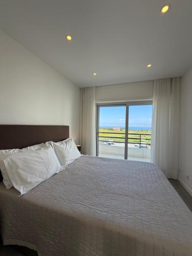 a bedroom with a large bed with a large window at AFIFE T1D Bouça Cabrita Residences in Afife