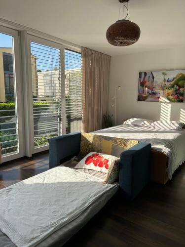a bedroom with two beds and a couch and windows at House Susanne in Cologne