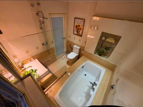 a large bathroom with a tub and a toilet at Aika Homestay in Shah Alam
