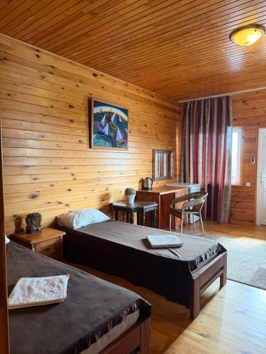 a bedroom with two beds in a wooden cabin at Mayak Resort in Kam”yani Potoky