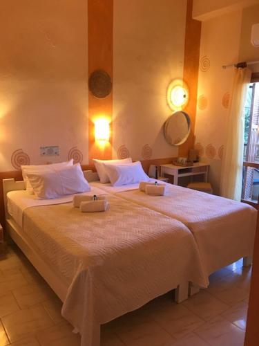 a bedroom with a large bed with two towels on it at Pension Aretoussa in Pitsidia
