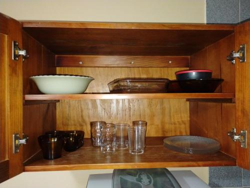 a wooden cabinet with glasses and bowls on it at Residencial Lumar in Itapoa