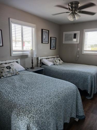 a bedroom with two beds and a ceiling fan at Carolina Blue in North Myrtle Beach