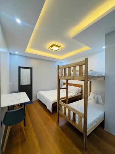 a room with two bunk beds and a desk at Aladdin's Guest House in Coron