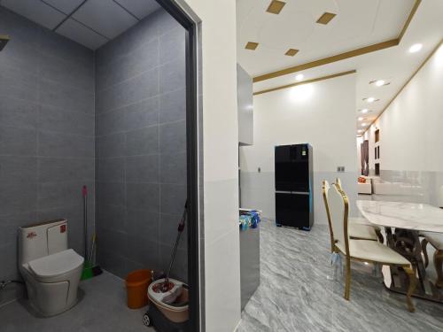 a bathroom with a toilet and a table with chairs at MAY homestay in Phú Khương