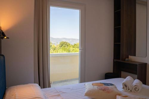 a bedroom with a bed and a large window at Blue Velvet apartment in Lumbarda