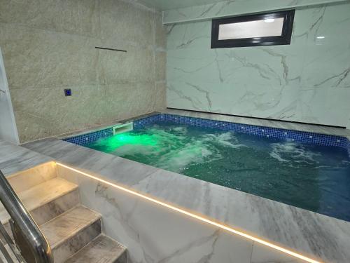 a jacuzzi tub in a bathroom with stairs at Hotel Al Abraj in Oran