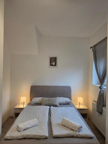 a bedroom with a bed with two pillows on it at Smeraldo Home Fsz in Siófok