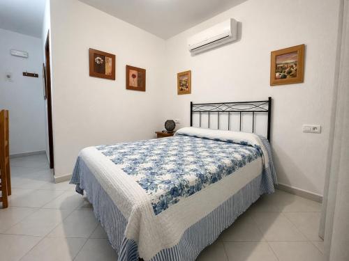 a bedroom with a bed with a blue and white blanket at Hostal Muriel in Aljaraque