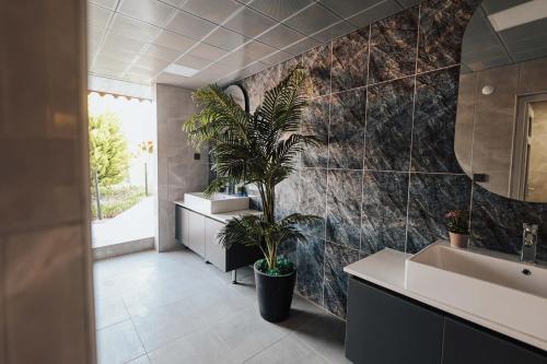 a bathroom with two sinks and a potted plant at Seyr-i Mavi Bungalow in Mavikent
