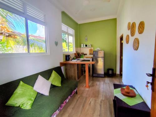 a living room with a green couch and a kitchen at Green Eyes Villa in Habaraduwa Central