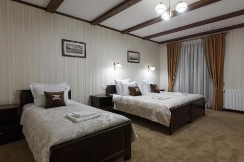 a hotel room with two beds in a room at Gasthaus & Spa Bukovel in Bukovel