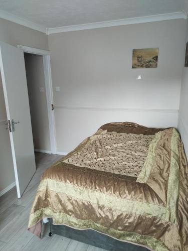a bedroom with a bed with a blanket on it at Murston Double Room in Kent
