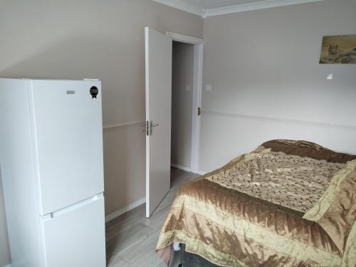 a white bedroom with a bed and a closet at Murston Double Room in Kent