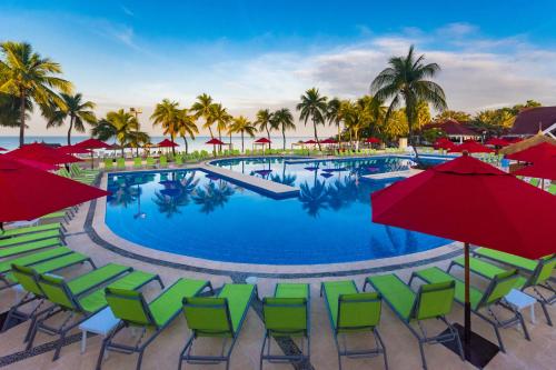 a swimming pool with chairs and umbrellas at Royal Decameron Indigo - All Inclusive in Montrouis