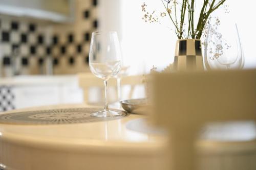 a wine glass sitting on a table with a vase at Private Parking & Garden -Luxury B&B-700mt Tower in Pisa