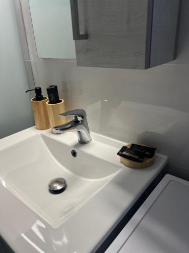 a white bathroom sink with a faucet and a mirror at Urban Nest Corinth in Korinthos