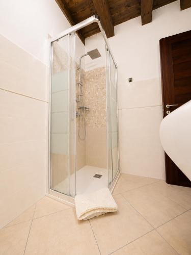 a shower with a glass door in a bathroom at L'Antica Torre Caralis Holiday in Cagliari