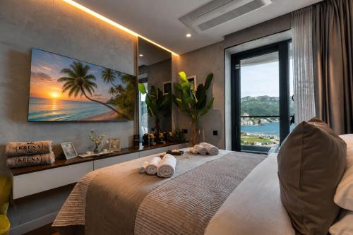 a bedroom with a large bed with a large window at KRUNA 406 Luxury Sea View Apartment with Parking, Minibar, Spa & Beach - Includes 2 Complimentary Non-Alcoholic Beach Drinks & Welcome Gift in Budva