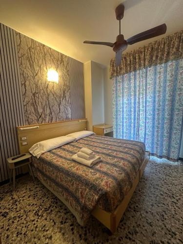 a bedroom with a bed with two towels on it at Hotel Magnolia in Albenga