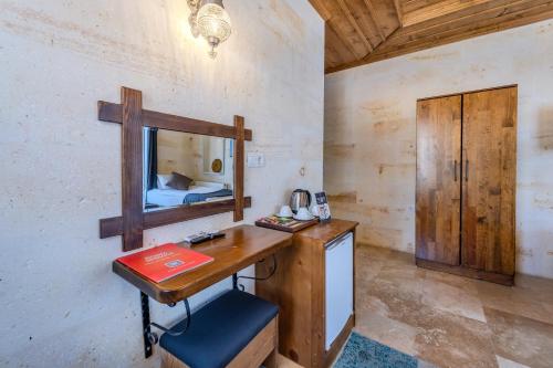 a room with a desk with a mirror and a bed at Rocca Stone House in Göreme
