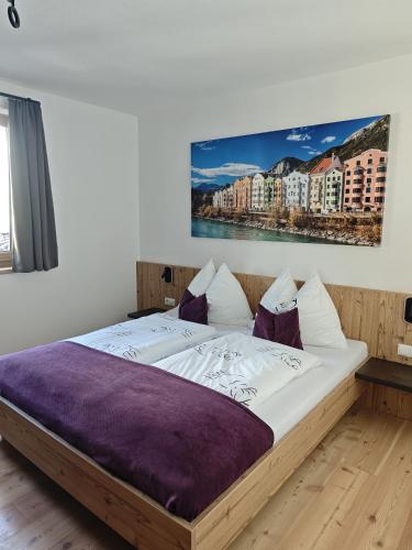 a bed in a bedroom with a painting on the wall at Studler-Eck in Oberperfuss