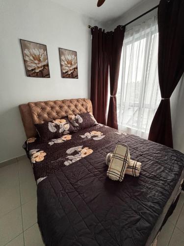 a bed with a black comforter and a bag on it at RAF Homestay Seri Serindit in Malacca