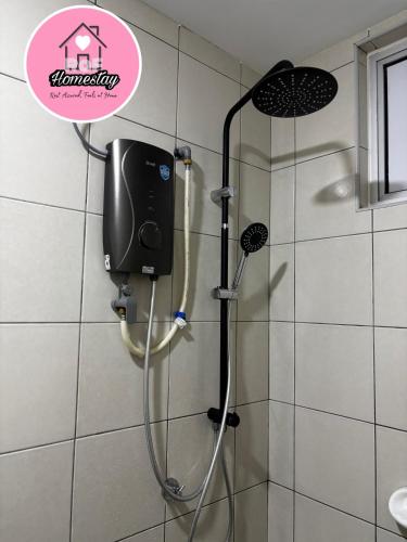 a shower in a bathroom with a sign on the wall at RAF Homestay Seri Serindit in Malacca