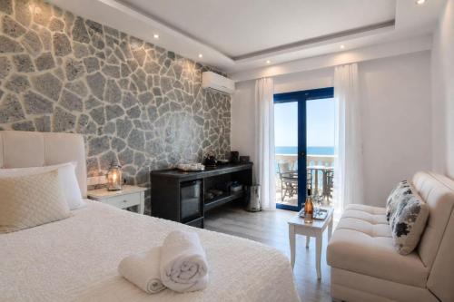 a bedroom with a bed and a couch and a window at Ocean View Rooms in Paralia Vrachou