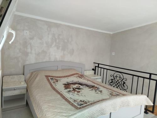 a small bedroom with a bed with a blanket on it at Apartments Svetlana in Utjeha